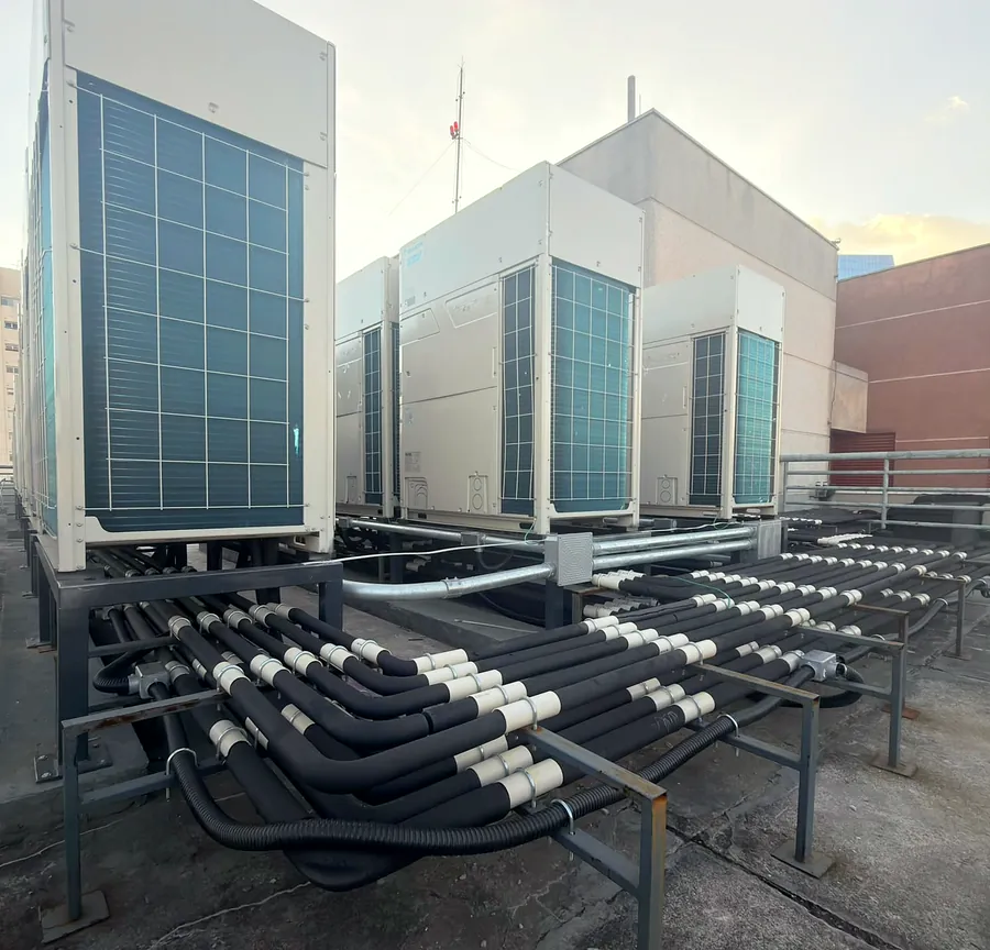 Condensadoras VRV instaladas em cobertura de edifício, com linha frigorígena isolada sobre suportes metálicos